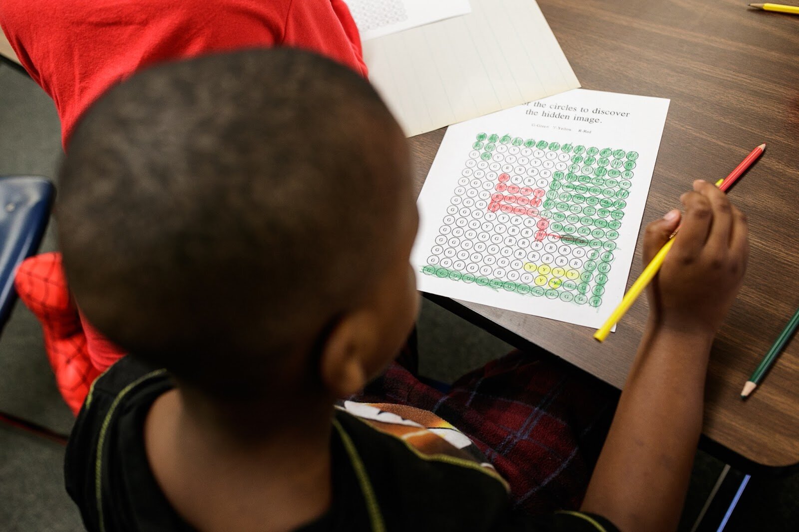 A first-grade Freeman scholar works on a coloring project in class during Freeman Elementary’s holiday celebration of literacy and reading comprehension on Friday, Dec. 16, 2022. (Jenifer Veloso | Flintside)

