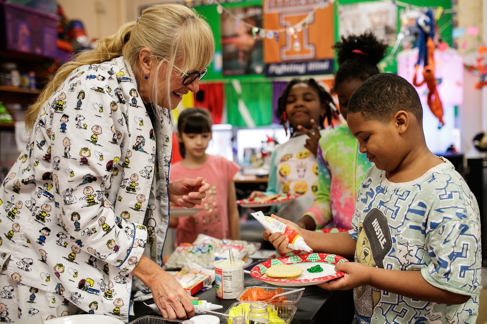 Third-grade teacher Mrs. Curtis helps students decorate Christmas cookies during Freeman Elementary’s holiday celebration of literacy and reading comprehension on Friday, Dec. 16, 2022. (Jenifer Veloso | Flintside)
