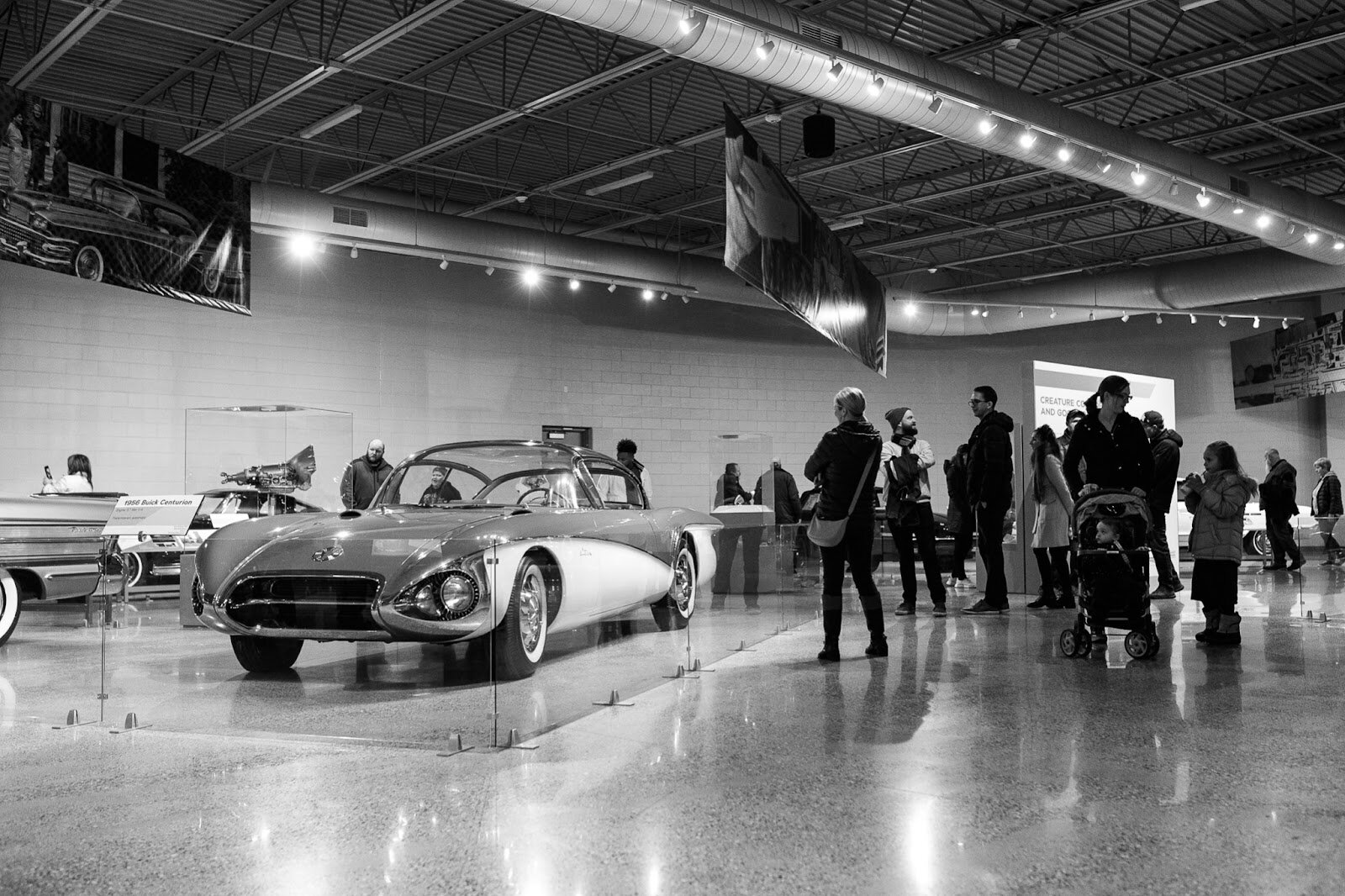 Sloan Museum guests walk through a history of Flint cars exhibit during the College Cultural area’s 37th Annual Holiday Walk in Flint on Tuesday, Dec. 6, 2022. (Jenifer Veloso | Flintside)
