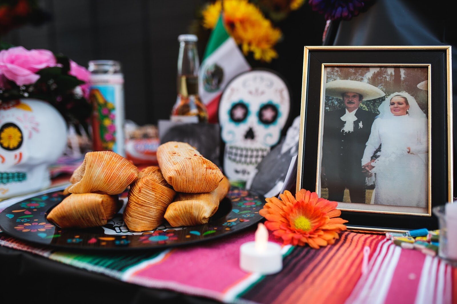 An ofrenda, decorated with photos of deceased loved ones, tamales, calaveras and flowers sits on display in Buckham Alley during the Latinx Technology and Community Center's Dia de Los Muertos celebration on Wednesday, Nov. 2, 2022 in downtown Flint. (Jenifer Veloso | Flintside)