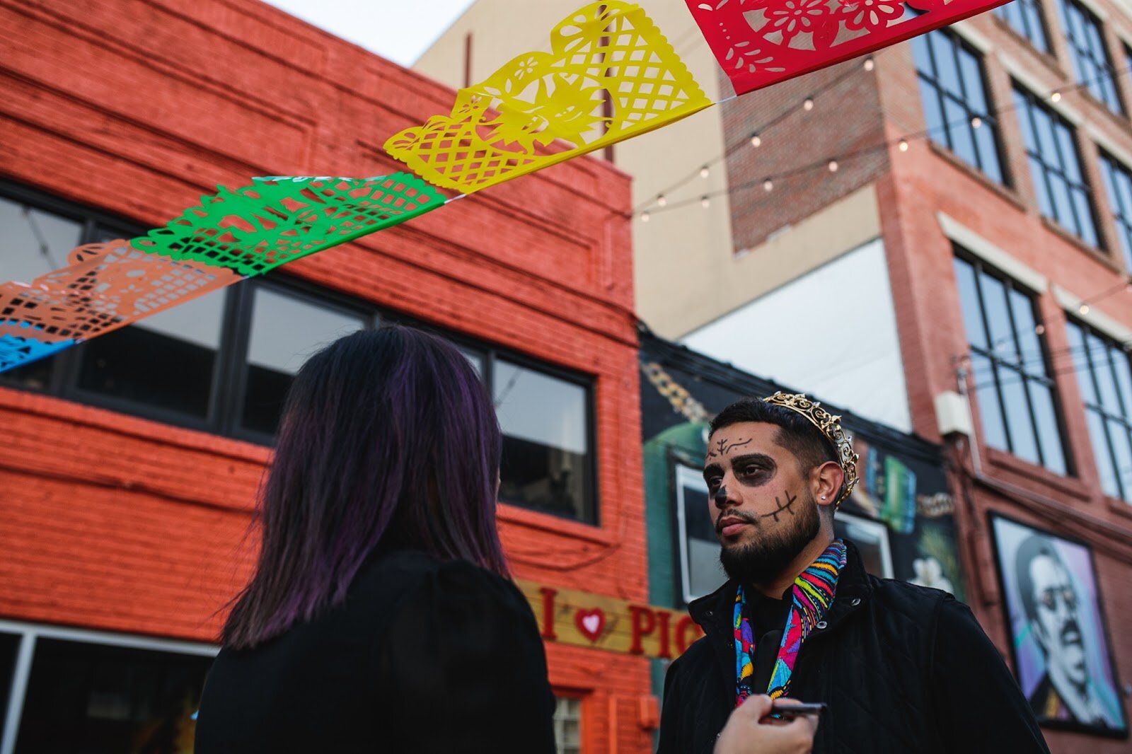 Midred Silva-Zuccaro places calavera makeup on Asa Zuccarro's face during the Latinx Technology and Community Center's Dia de Los Muertos celebration on Wednesday, Nov. 2, 2022 in downtown Flint. (Jenifer Veloso | Flintside)
