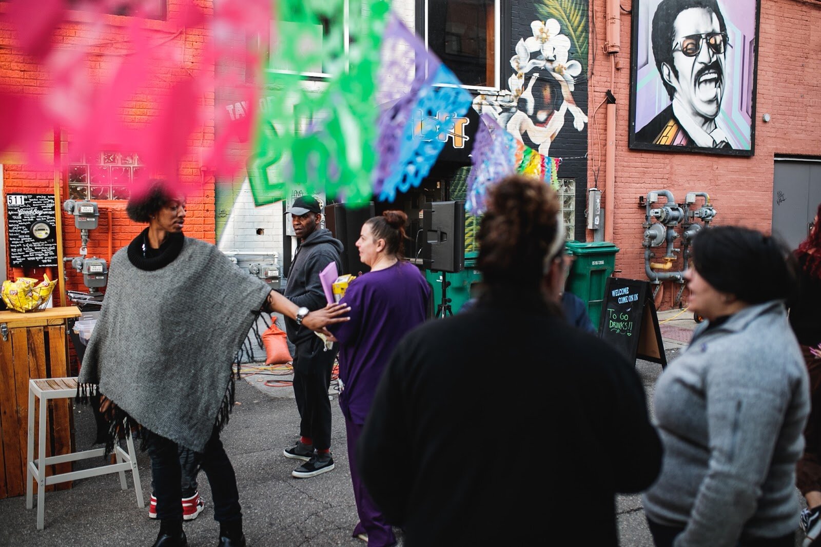 Friends greet one another during the Latinx Technology and Community Center's Dia de Los Muertos celebration on Wednesday, Nov. 2, 2022 in downtown Flint. (Jenifer Veloso | Flintside)