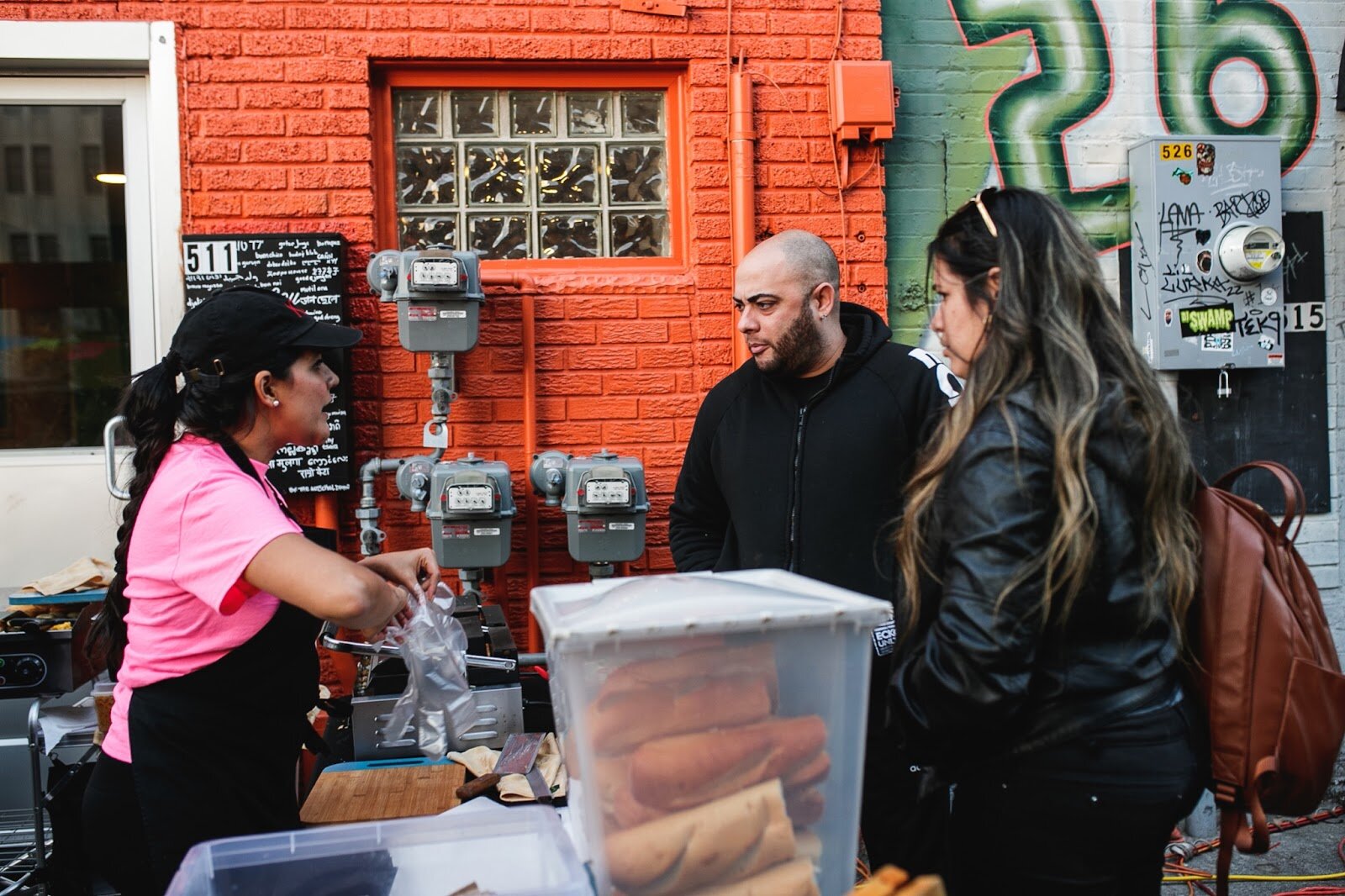 Aliza Mendoza, from I <3 Pig, takes an order for arepas during the Latinx Technology and Community Center's Dia de Los Muertos celebration on Wednesday, Nov. 2, 2022 in downtown Flint. (Jenifer Veloso | Flintside)