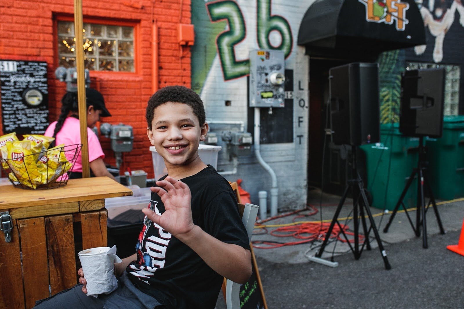 An attendant smiles and waves during the Latinx Technology and Community Center's Dia de Los Muertos celebration on Wednesday, Nov. 2, 2022 in downtown Flint. (Jenifer Veloso | Flintside)