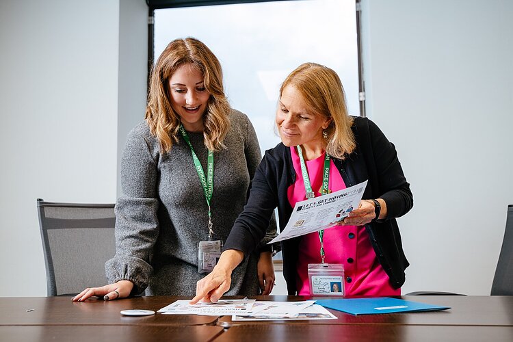 Sadie Shattuck and Laurie Arora look over handouts for The Power of Understanding.