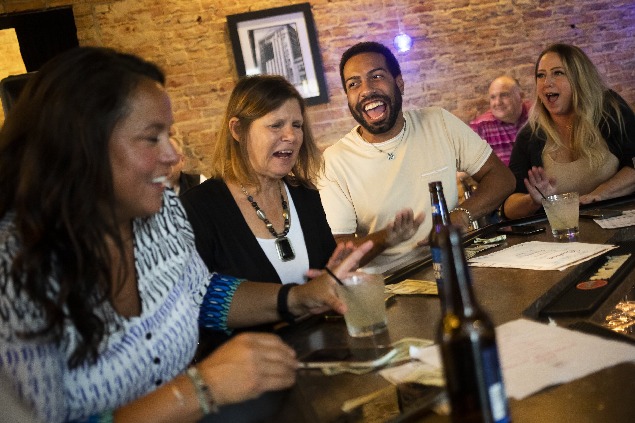Nicholas Hoist of Bay City, center right, thrums his hands on the bar with a group of friends during a Michigan Drag Brunch performance Sunday, Sept. 25, 2022 at 501 Bar and Grill in downtown Flint.