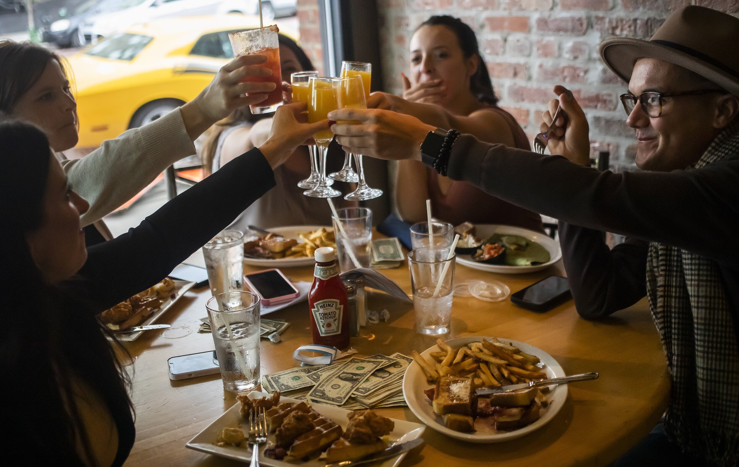 A group of friends holds up their drinks in a toast during a Michigan Drag Brunch performance Sunday, Sept. 25, 2022 at 501 Bar and Grill in downtown Flint.