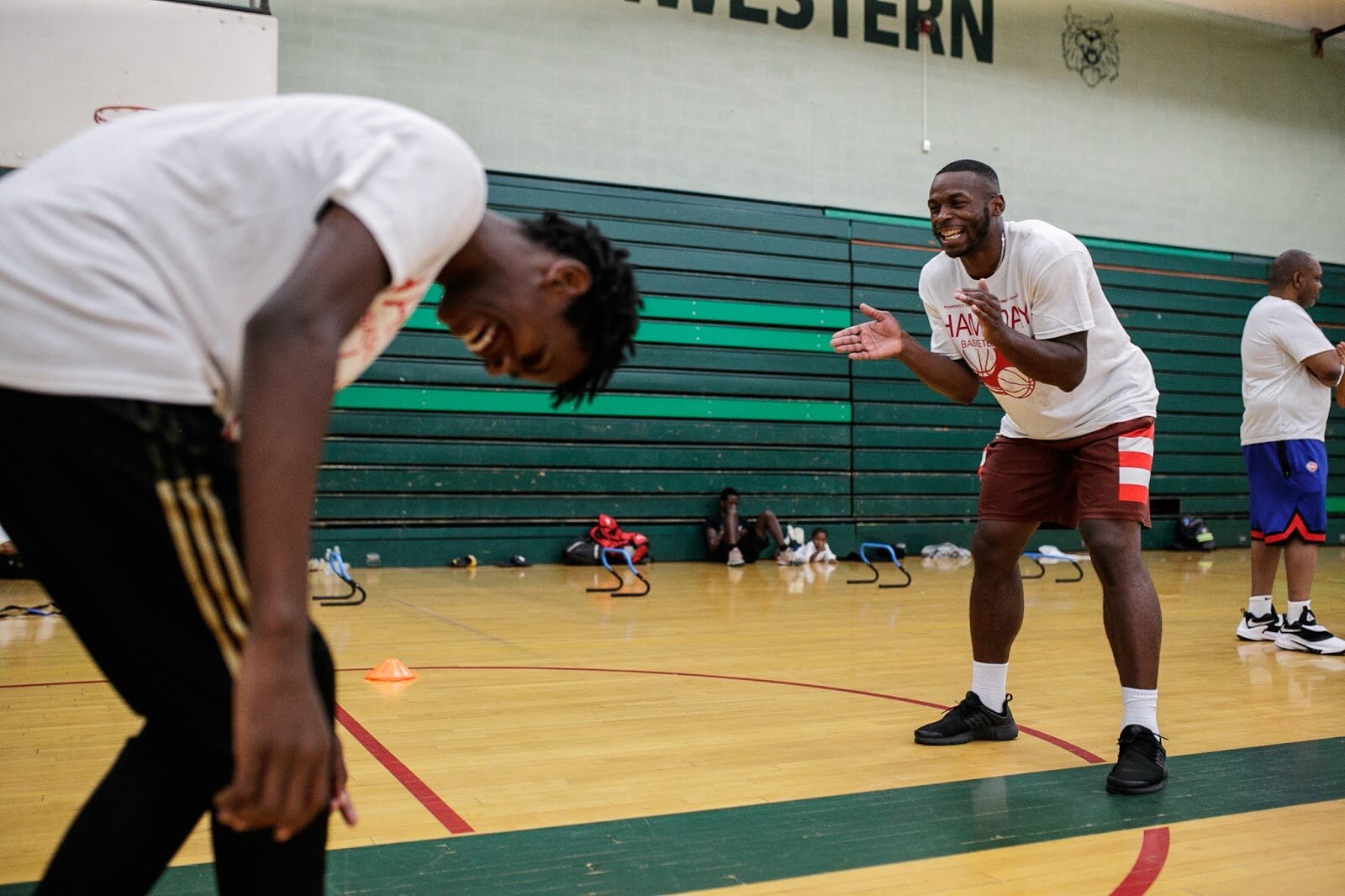 A coach laughs and encourages a player during Hami Day Camp at Flint Northwestern High School on Friday, Aug. 27, 2022. (Jenifer Veloso | Flintside.com)
