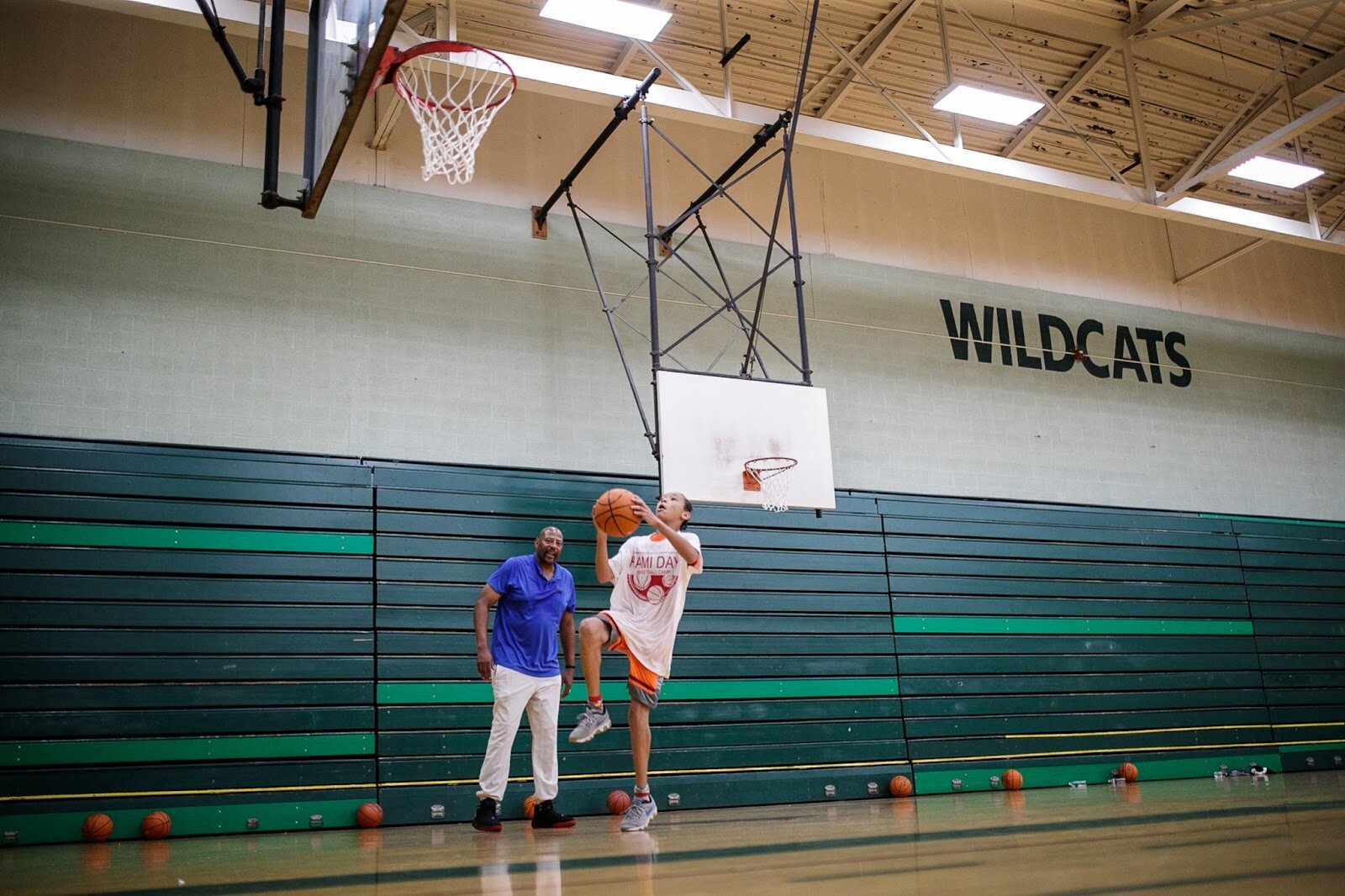 NBA champion Earl Cureton watches kids practice a lay-up during Hami Day Camp at Flint Northwestern High School on Friday, Aug. 27, 2022. (Jenifer Veloso | Flintside.com)
