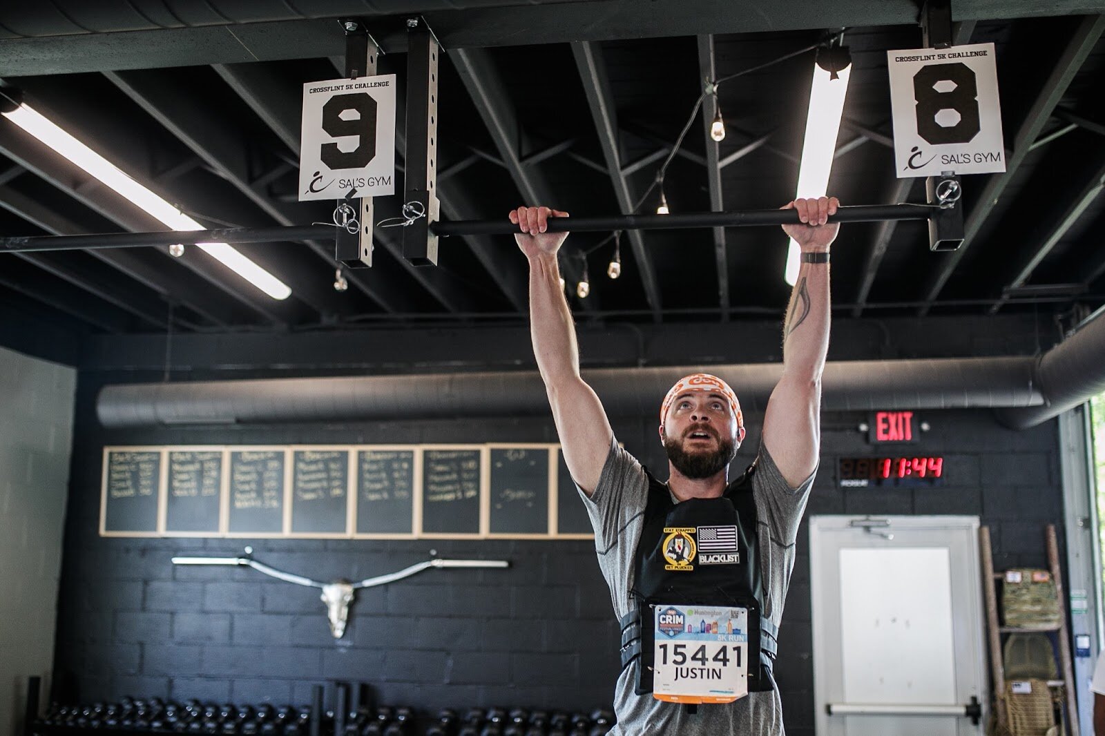 A CrossFlint 5K Challenge participant does pull-ups for the Weighted Challenge during the 45th annual Crim Festival of Races on Saturday, Aug. 27, 2022 in downtown Flint. (Jenifer Veloso | Flintside.com)

