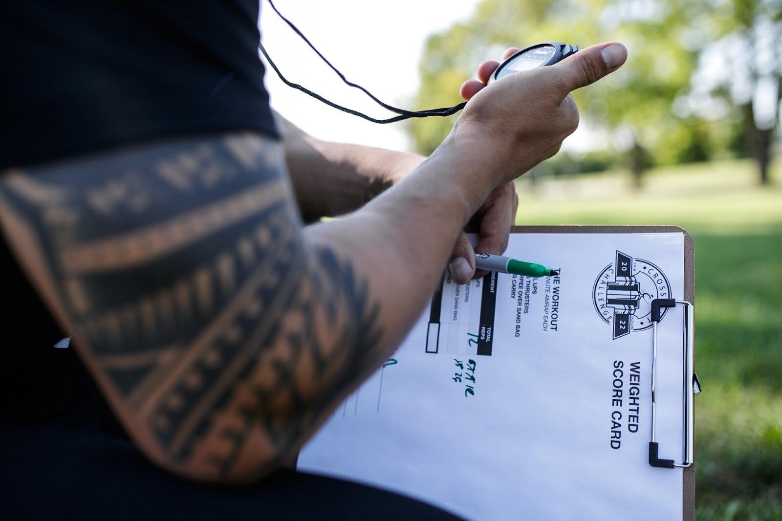 Sal's Gym co-owner Jake Saldaña keeps time for Weighted Challenge participant's pull-ups for the CrossFlint 5K Challenge during the 45th annual Crim Festival of Races on Saturday, Aug. 27, 2022 in downtown Flint. (Jenifer Veloso | Flintside.com)
