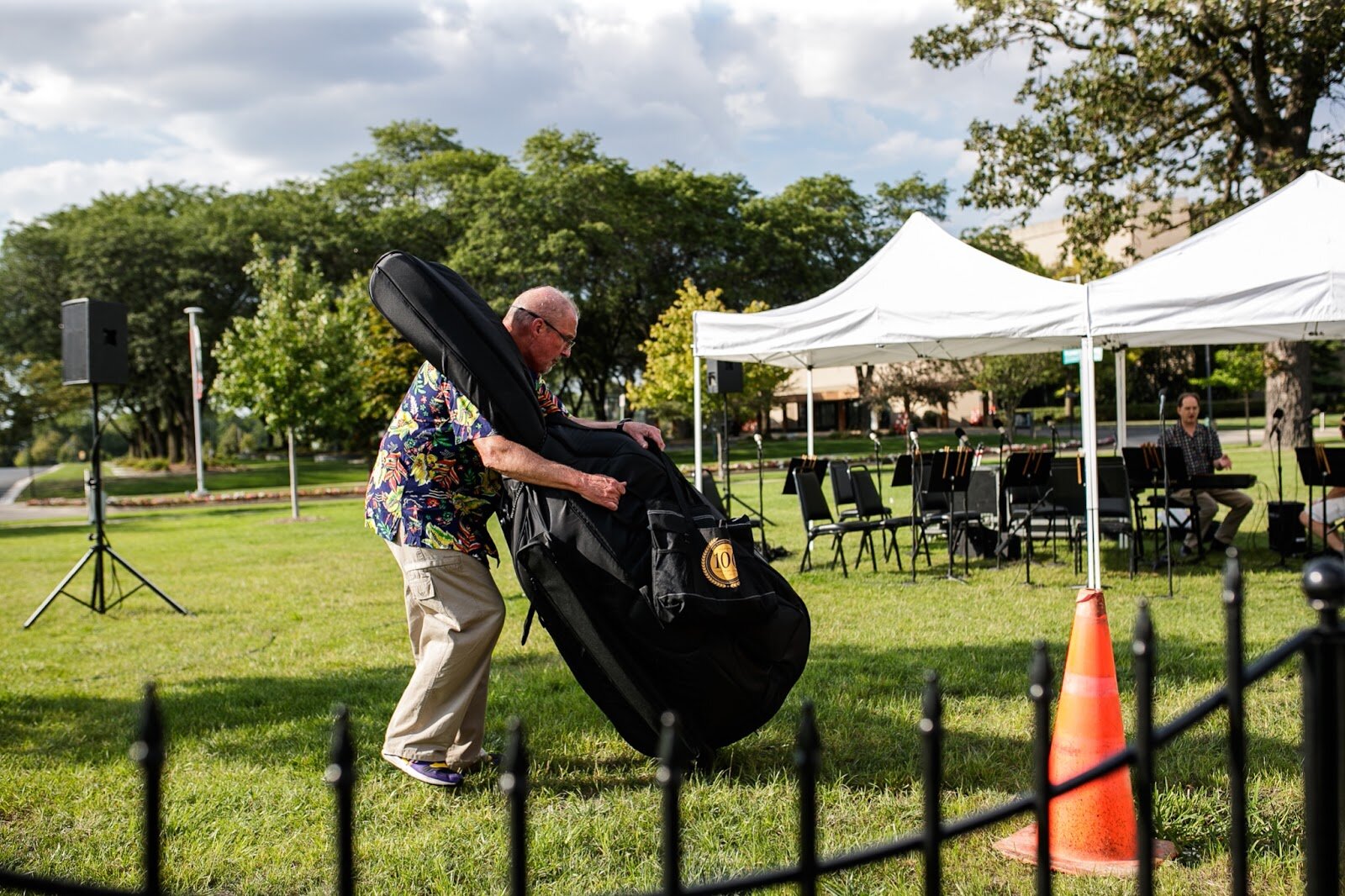 A cellist arrives with his instrument as part of the Flint Institute of Music’s ensemble during Family Night at 'Late Night at the FIA' on Friday, Aug. 19, 2022. (Jenifer Veloso | Flintside.com)
