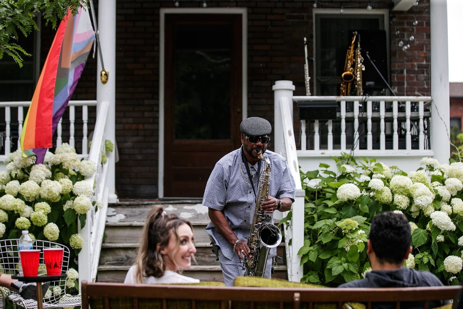 A couple is serenaded by saxophone during Porch Fest on Friday, July 15, 2022. (Jenifer Veloso | Flintside)
