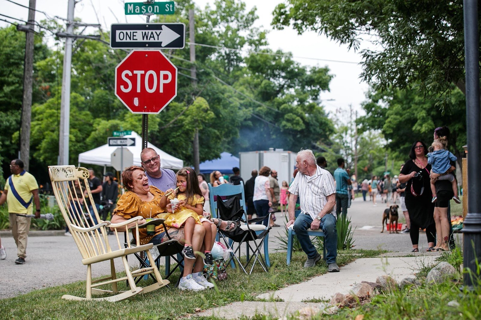 Robin, Jim, and Nyota sit and laugh together during Porch Fest on Friday, July 15, 2022. (Jenifer Veloso | Flintside)