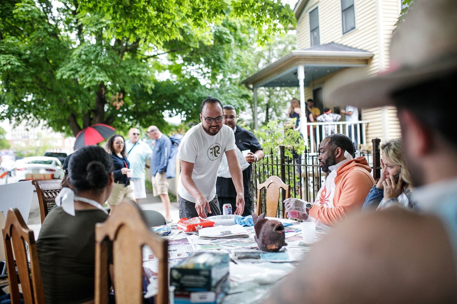 Tony Vu, the founder of Flint Social Club, welcomes dinner guests to his outdoor seafood boil during Porch Fest on Friday, July 15, 2022. (Jenifer Veloso | Flintside)