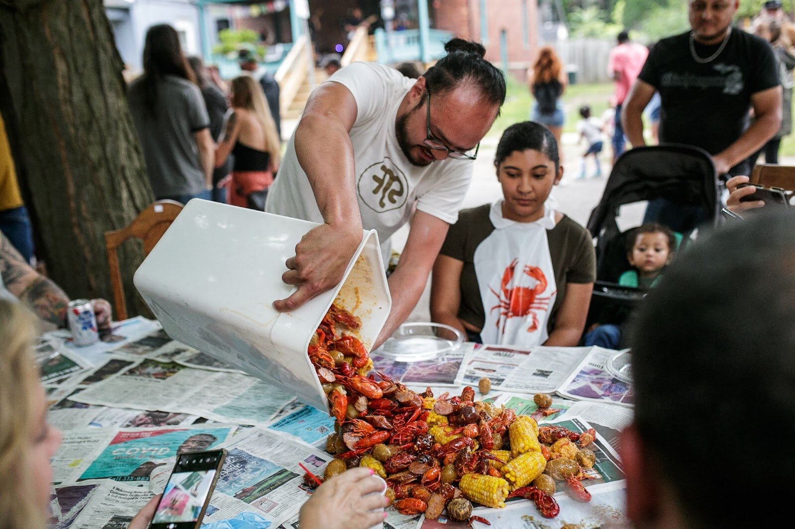 Tony Vu pours out a fresh seafood boil for guests during Porch Fest on Friday, July 15, 2022. (Jenifer Veloso | Flintside)