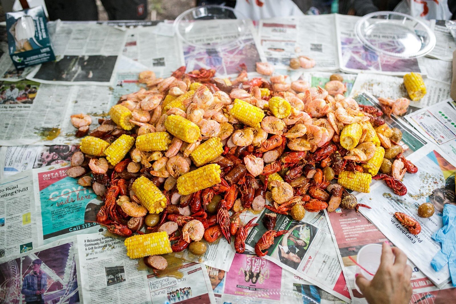 Tony Vu's fresh seafood boil rests on newspapers for dinner guests to eat during Porch Fest on Friday, July 15, 2022. (Jenifer Veloso | Flintside)
