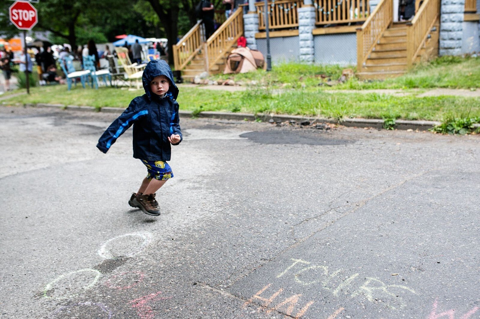 A kid plays in the rain during Porch Fest on Friday, July 15, 2022. (Jenifer Veloso | Flintside)