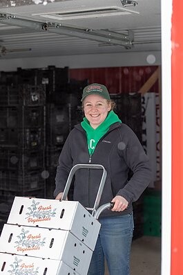 A farmer loads a truck with fresh vegetables for a local food pantry.
