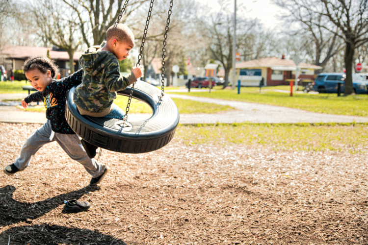 Two neighborhood kids playing on the tire swing at Sarvis Park.