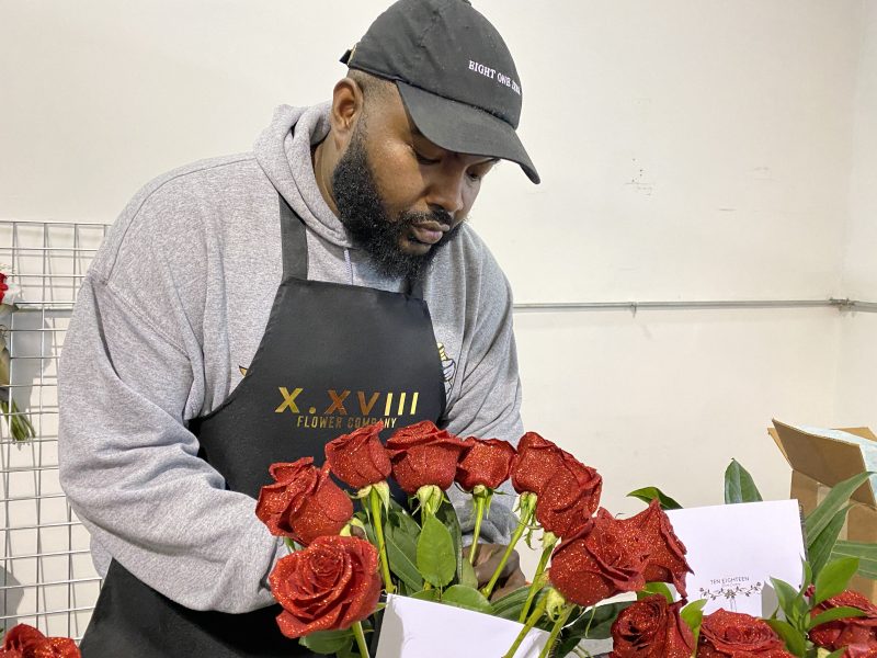 Flint native Randall Wilburn arranges a bouquet of roses from his new flower company that he dedicated to his father.