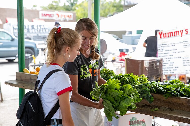 Amy St. Germain talks to visitors at the Muskegon Farmers Market.
