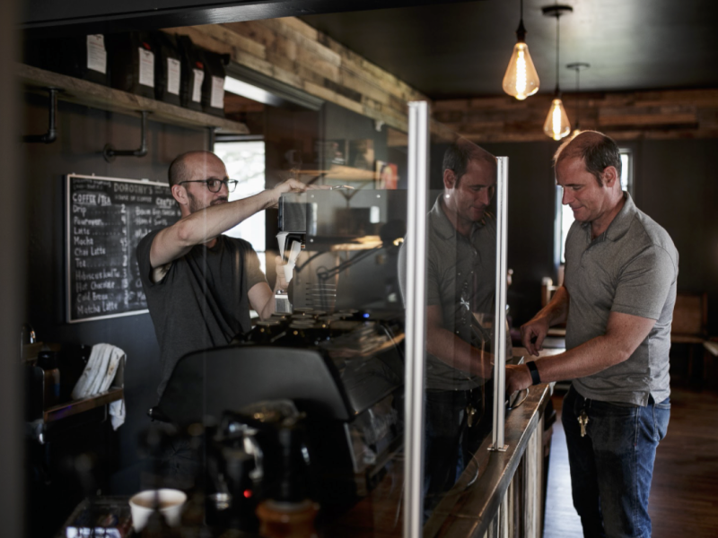 Timothy Goodrich preps a drink behind the coffee bar for a customer inside of Dorothy Day's Coffee House in East Village.