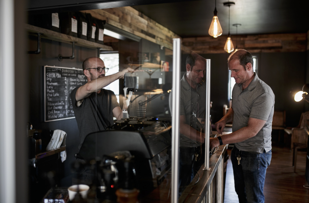 Timothy Goodrich preps a drink behind the coffee bar for a customer inside of Dorothy Day's Coffee House in East Village.