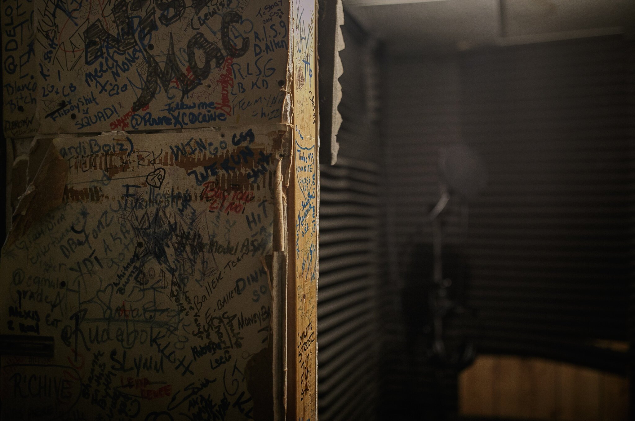 His studio, built in his basement, with chairs, a table, a desk full of recording equipment, and a wall autographed by Flint’s past, present, and future stars, provides a space for vulnerability and authenticity.