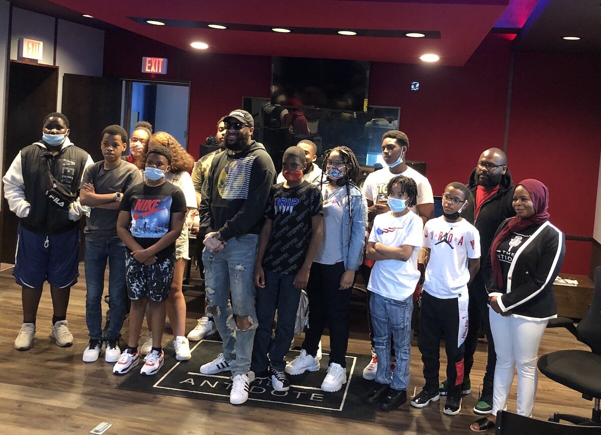 RushDee poses for phots with students and staff from The Antidote Studio.