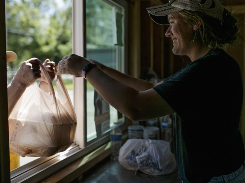 Maggie Guinther, 17, a volunteer from St. Martin Luther church, hands out meals to local residents