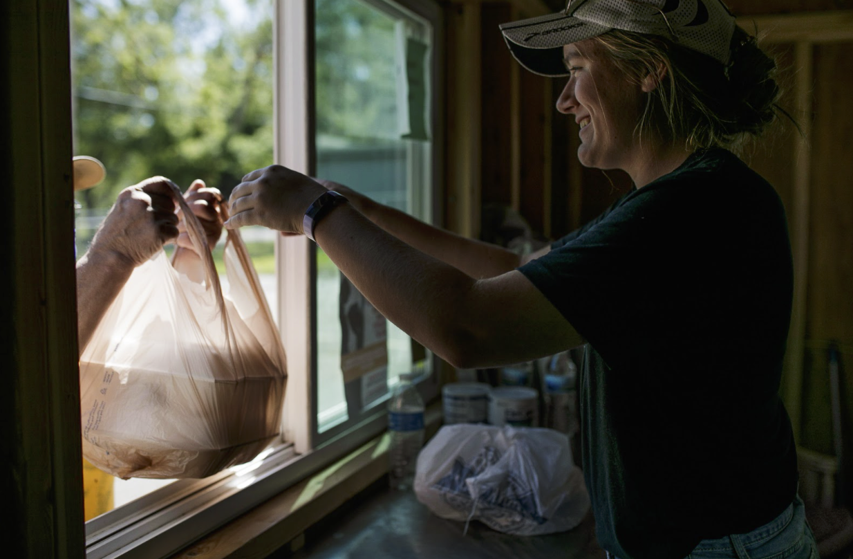 Maggie Guinther, 17, a volunteer from St. Martin Luther church, hands out meals to local residents 