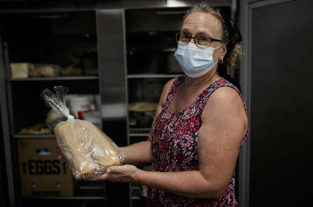 Arlene Casselman, a volunteer from St. Martin Lutheran Church, stores away the subs while the volunteers await residents to arrive at Franklin Avenue Mission.