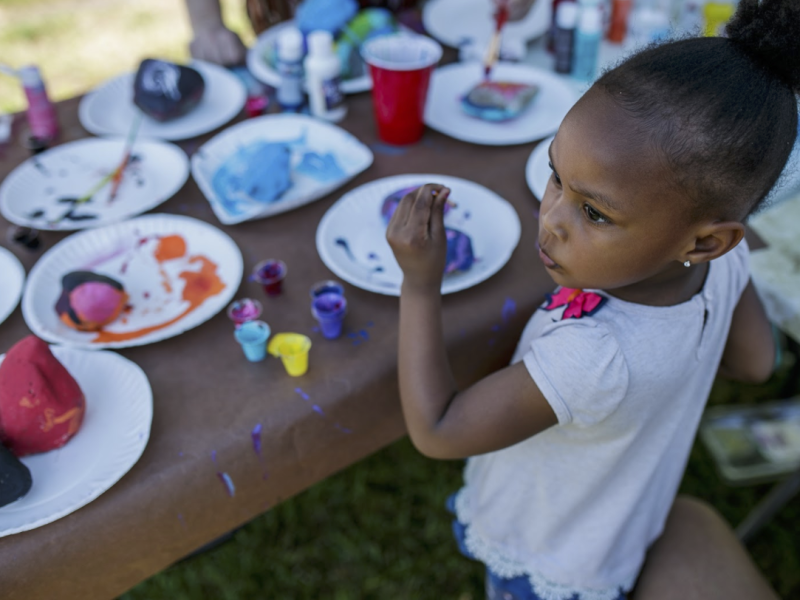 Layla Smith, 4, paints in a crafting area during a community event at Amos Park on June 5.