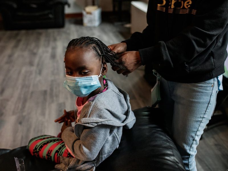 Chanelle Hodo, 26, a resident of Shelter of Flint, beads her daughter's hair.