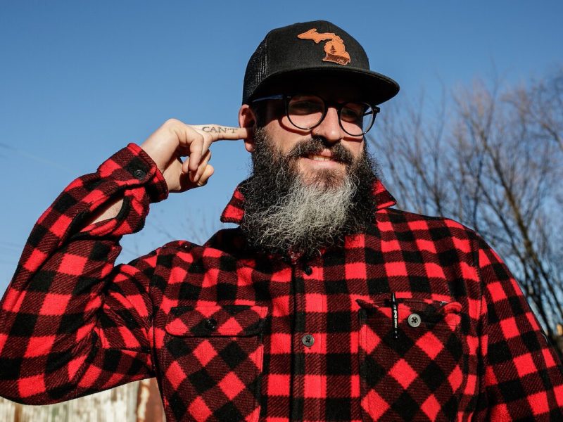 Clay Parks holds his middle finger with the word, "can't" tattooed on it, up to his ear.