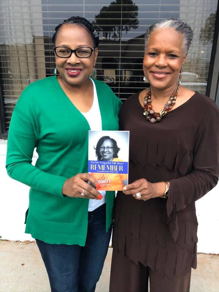 Brenda Brown poses alongside her sister-in-law with her book at a family gathering in December 2019.