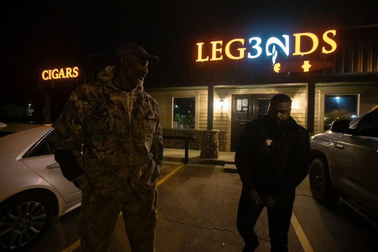 Eric Woodyard with NBA Hall of Famer Karl Malone outside of Legends Cigar and Vape, owned by Malone and his daughter, in Ruston, Louisiana.