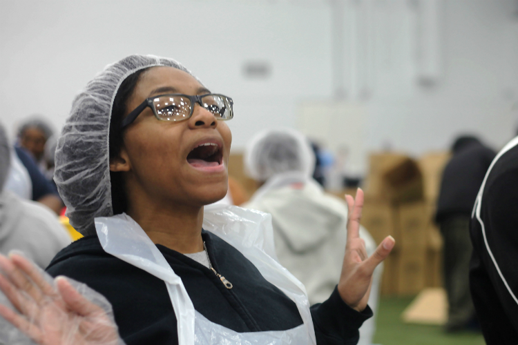 Americorps volunteer Taylor Joyce yells, “BEANS!” for a refill of dried beans that will be added to meals on the United Way Food Drive to celebrate the Martin Luther King holiday. 