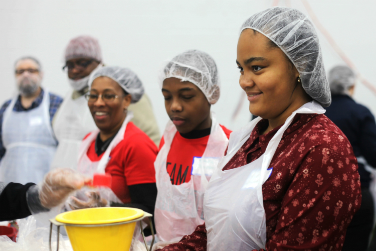 Kaylynn Grandberry, 13, works along with her friends and family to helps back meals. Her father said, “It’s important to get the whole family here ... but even more important is for them to gain a deeper understanding of the issues that are happening