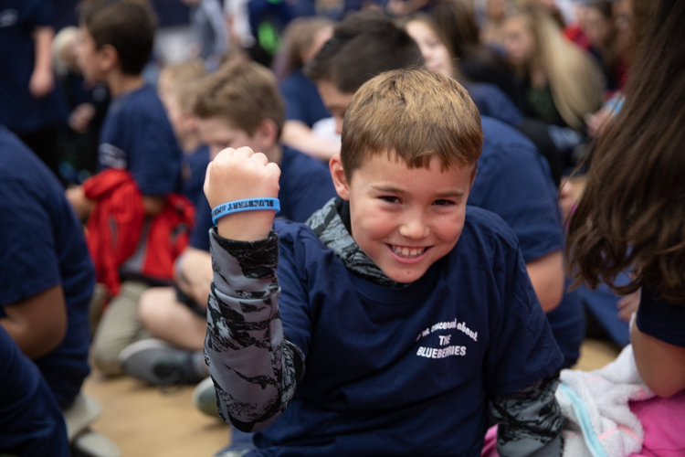 A Blueberry Ambassador shows of his wristband, an identifier of students who participate in the random acts of kindness campaign. 