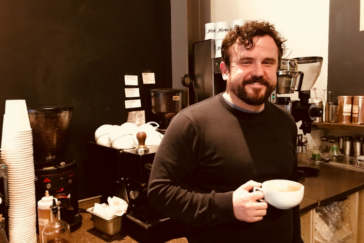 Jake Carah, the author of this article and regretful hipster, stands before the espresso machines at Flint Crepe Company servicing his caffeine addiction.