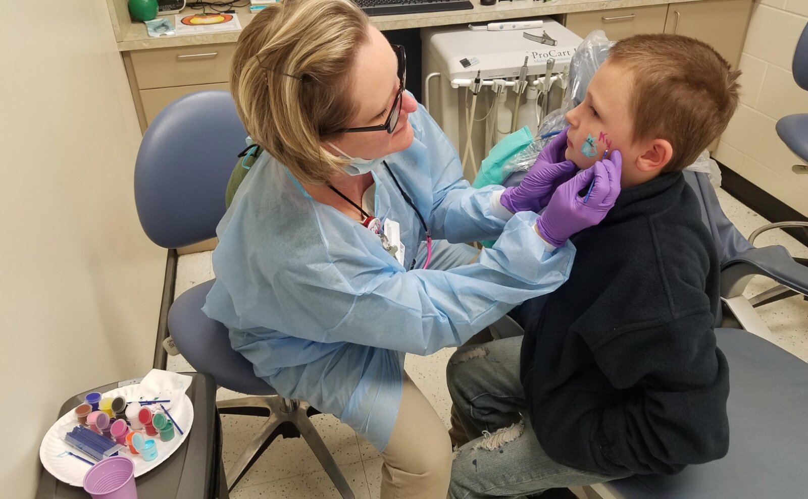 After receiving dental care at the Delta Dental Center at Oyler, a student gets their face painted while waiting for the bus back to school.