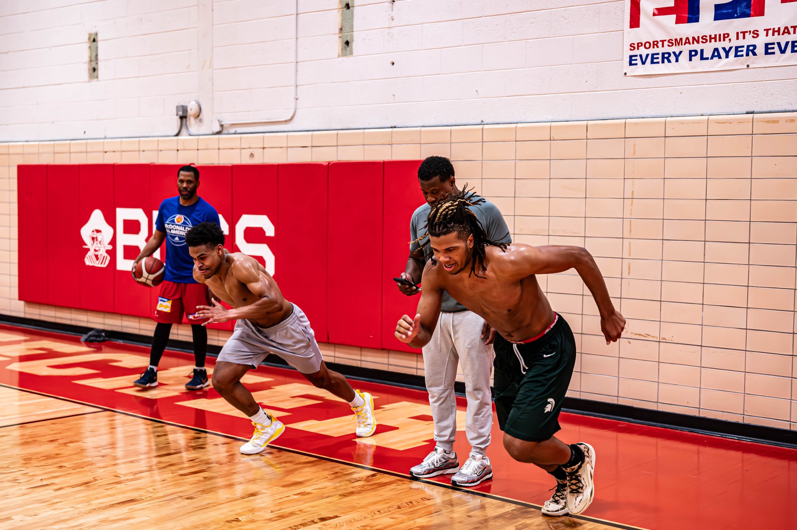K.C. Cavette (right) and Greg Burks(left) working on running drills with
Trey McKenney (right) and Phoenix Marble (left). (Ray Gray | Flintside.com)