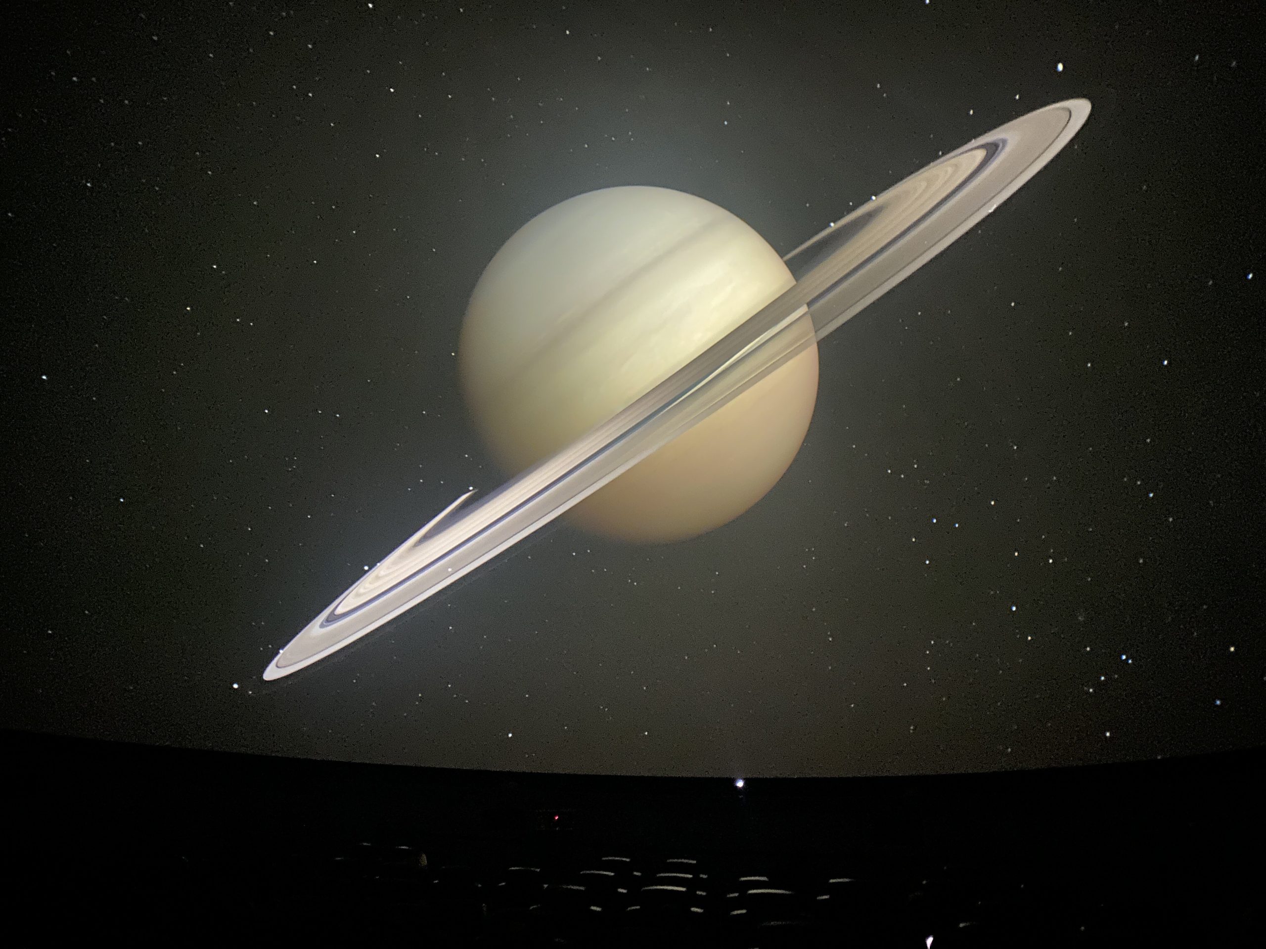 A large image of Saturn is displayed during Jon Connor's listening party for his newest album "III" at Longway Planetarium in Flint on Wednesday, Jan. 24, 2024. (Tia Scott | Flintside)
