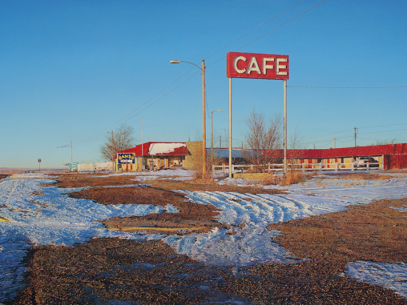 Rod Penner, American, b. Canada, 1965. Sands Motel & Café, 2019. Acrylic on canvas, 31 x 64 in. Collection of Louis K. and Susan P. Meisel.