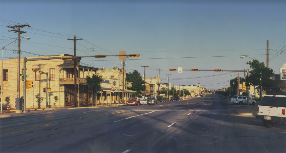 Rod Penner, American, b. Canada, 1965. Orange Street and Main / Fredericksburg, TX, 1999. Acrylic on board, 18 x 33 ½ in. Collection of Louis K. and Susan P. Meisel.