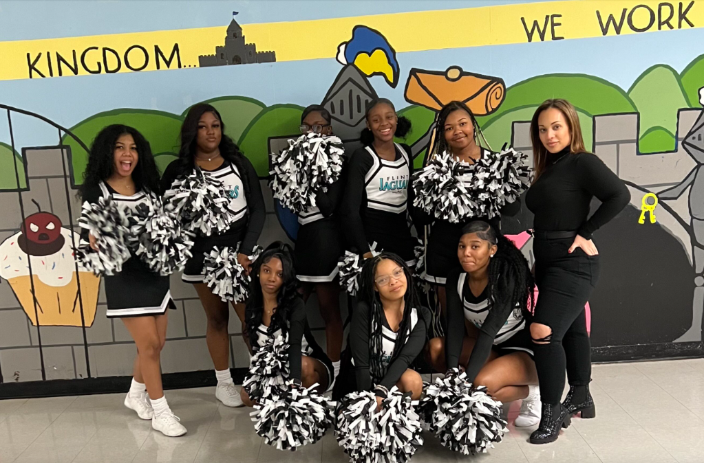 Danielle Parks poses with members of the cheer squad of Flint Southwestern Classical Academy.