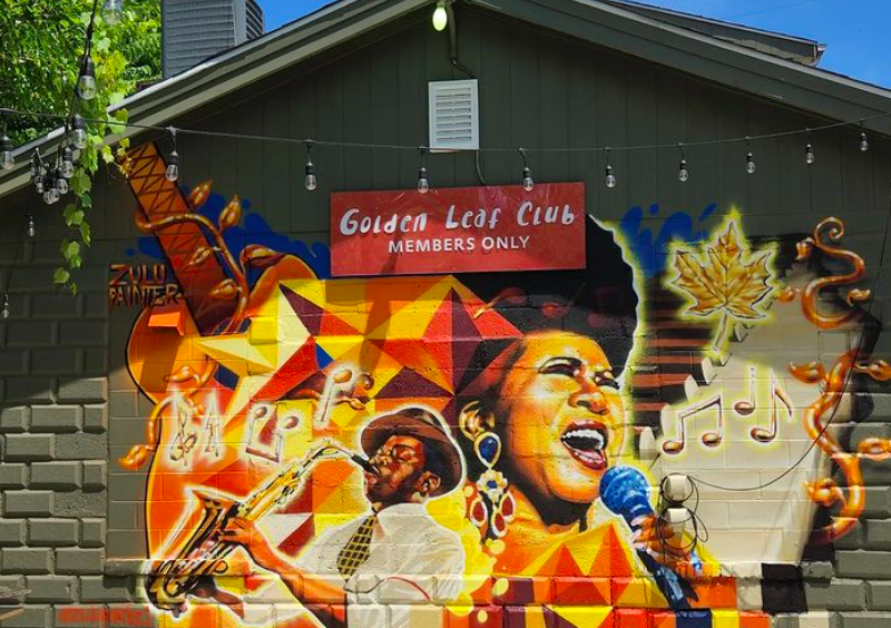 The new mural at The Golden Leaf captures elements of music notes, golden leaves, and the legendary Aretha Franklin mid-song.