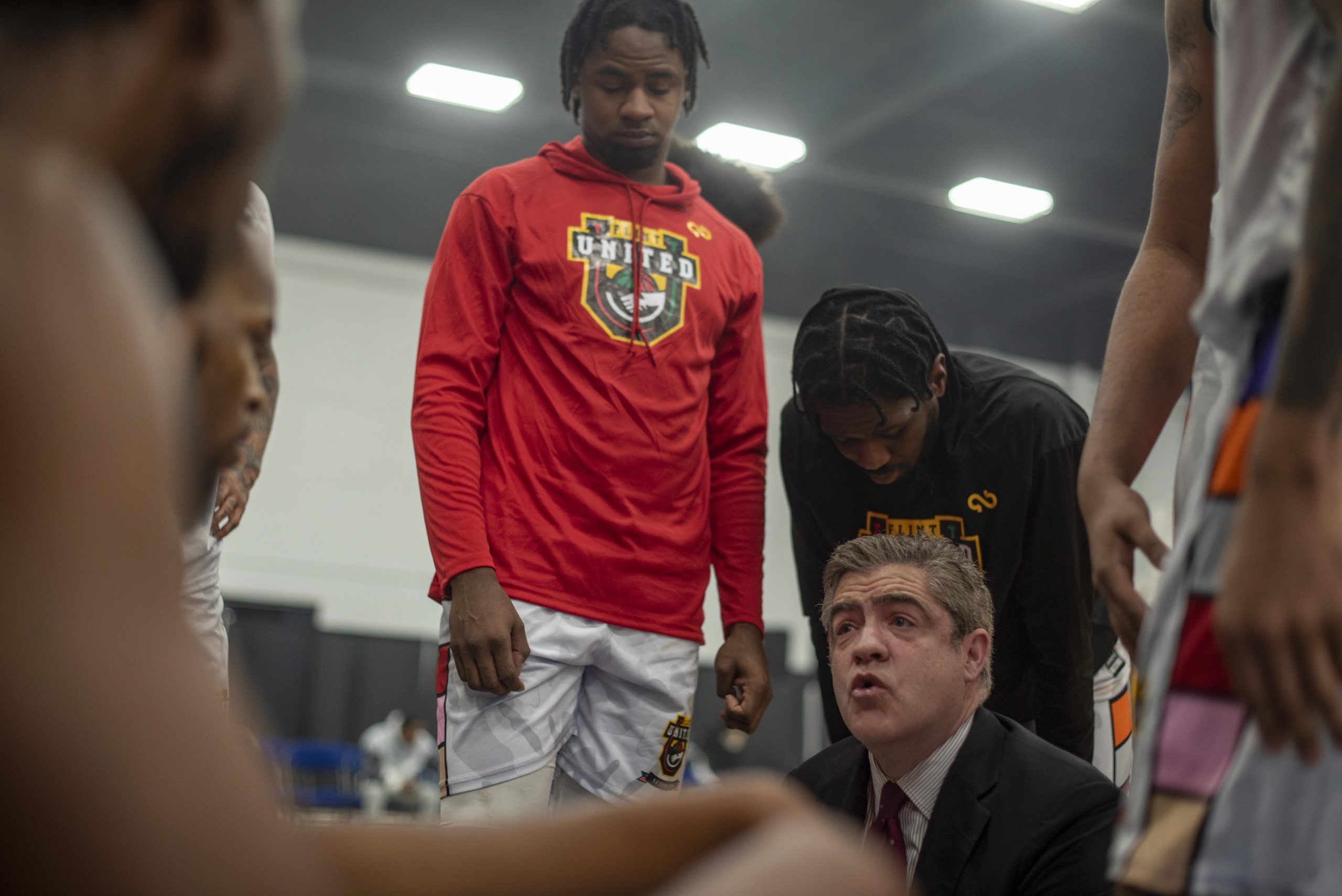 Flint United Head Coach Keno Davis talks strategy with his team during a time-out in the game’s second quarter.
